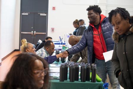 Man attending a WORC event smiling and shaking hands with Francine Washington.