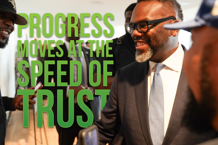 The words "Speed of Trust" in green on a photo of Chicago Mayor Johnson and Constituents